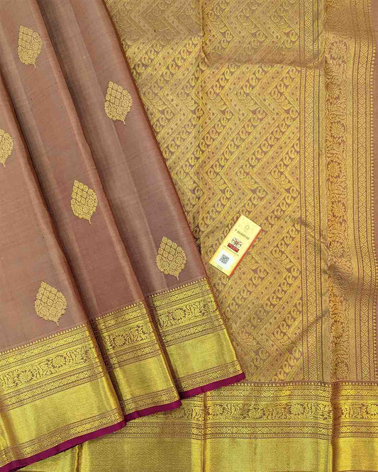 Traditional gold silk saree with leaf buttas, gold border, and intricate pink designs.