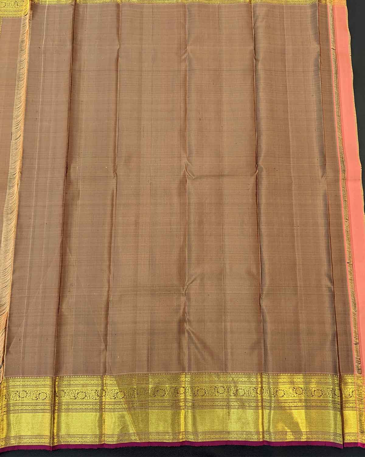 Traditional gold silk saree with leaf buttas, gold border, and intricate pink designs