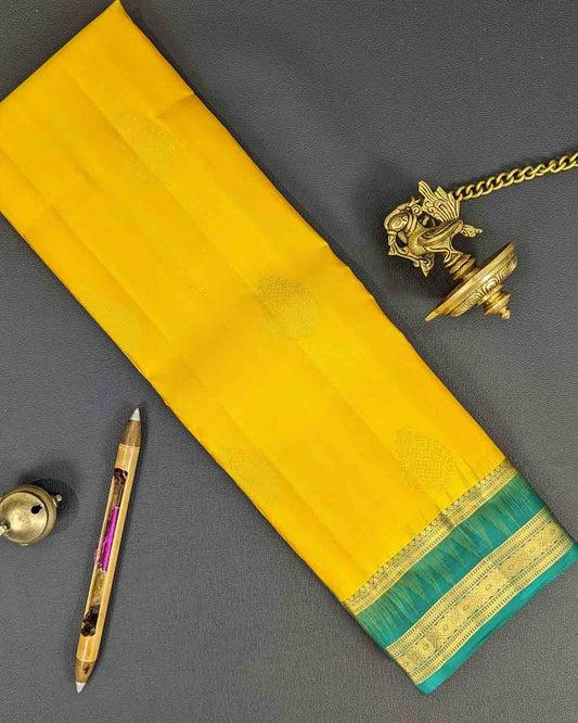 Bright yellow Kancheepuram silk sarees with contrasting border and intricate pallu.