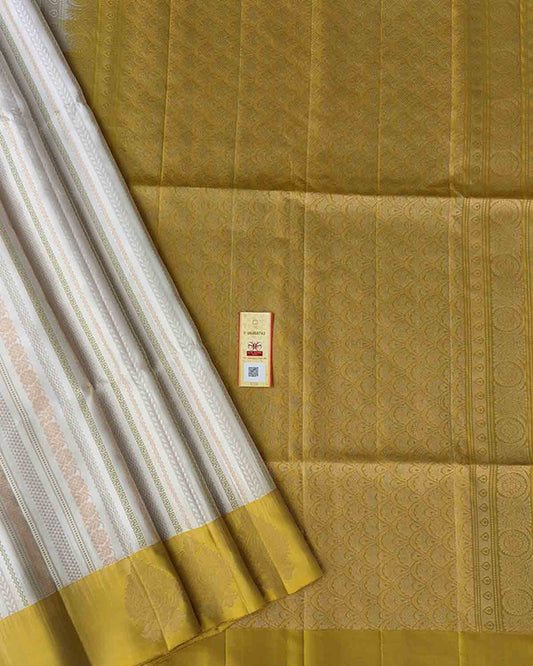 Pastel beige Kanchipuram silk sarees with striped body and paisley zari border