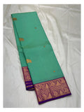 Aqua green saree body with elephant motifs and wide purple woven border shown laid out