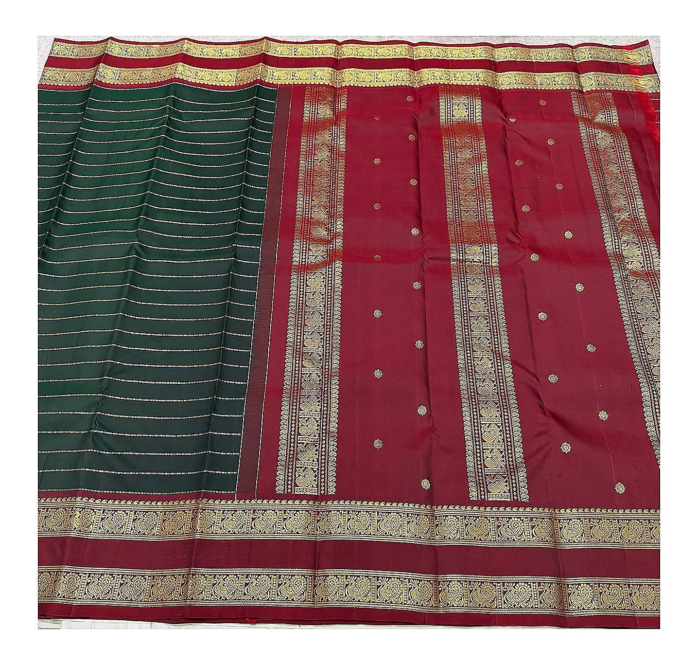 Handwoven Kanchipuram silk saree with deep green striped body and maroon pallu spread out