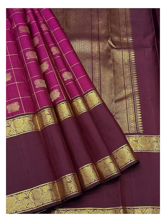 Draped view showing the deep magenta checks, plum zari pallu, and peacock-style border