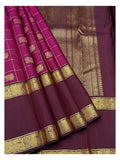 Draped view showing the deep magenta checks, plum zari pallu, and peacock-style border