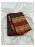 Handwoven Kanchipuram silk saree folded to show the deep plum body with fine butta pattern and maroon border with gold-toned woven motifs