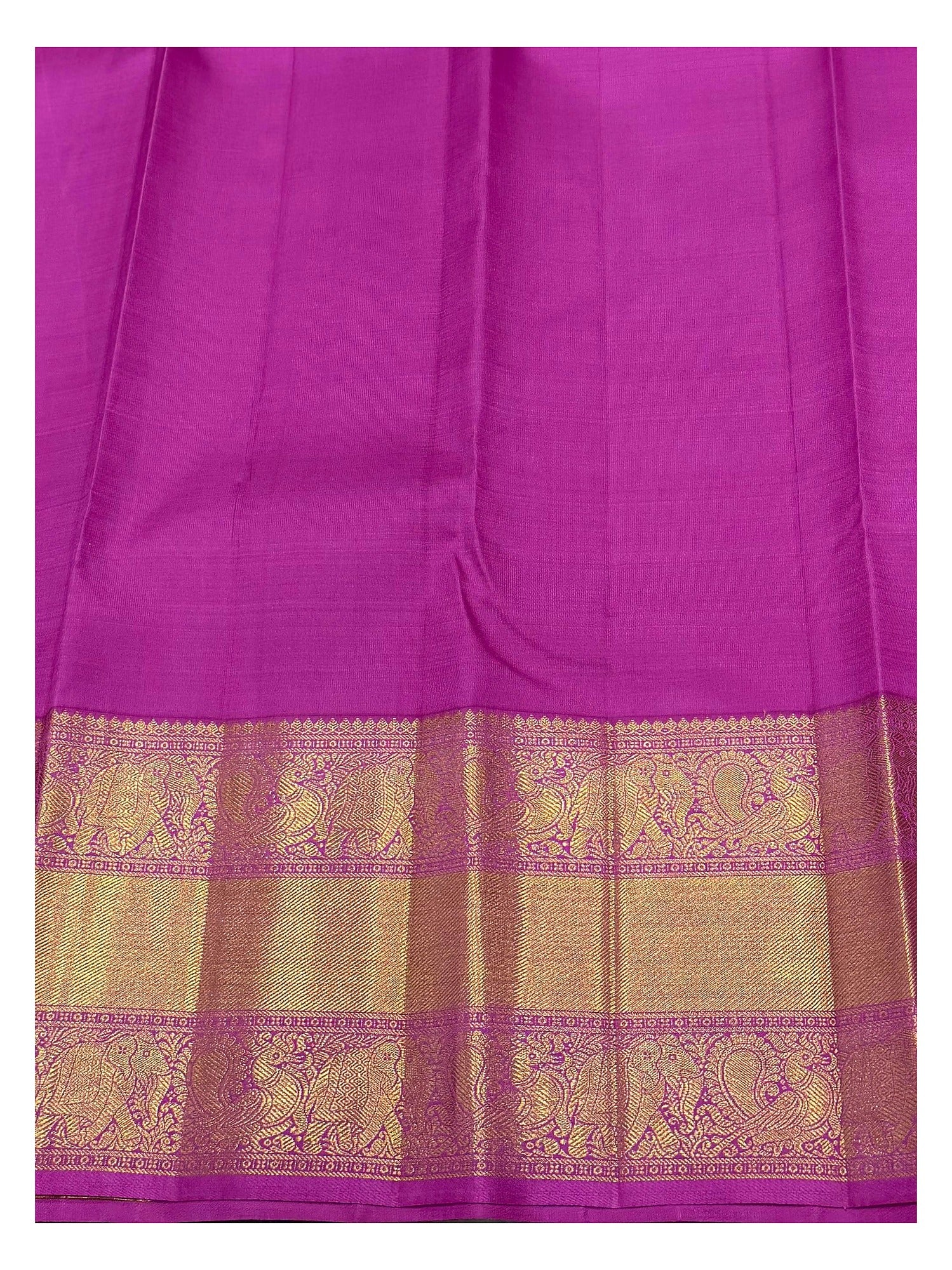 Close view of the magenta and gold-toned elephant motif border on a handwoven Kanchipuram silk saree