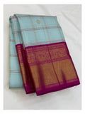 Folded handwoven Kanchipuram silk saree in ice blue checks with magenta border