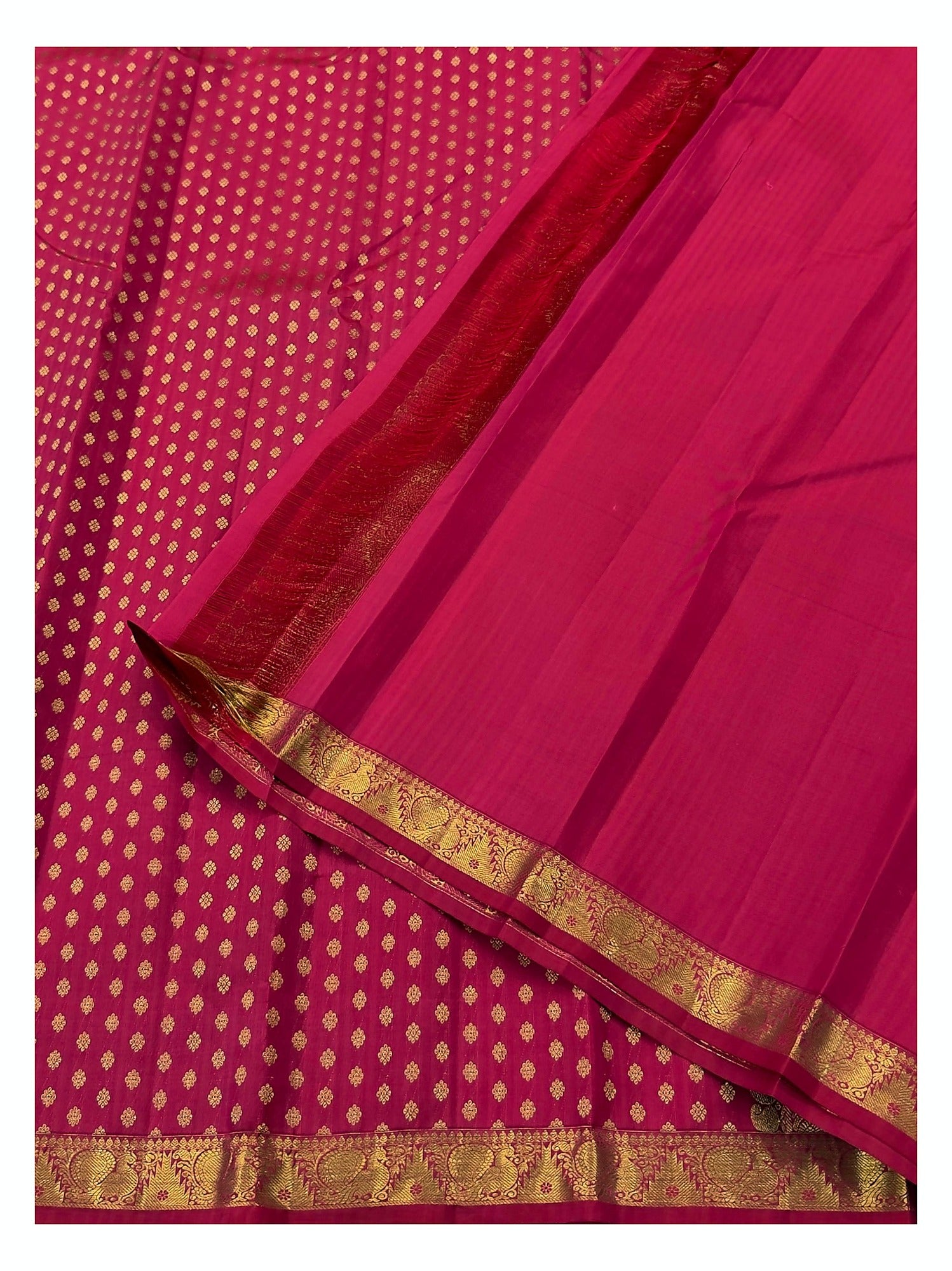 Rani pink Kanchipuram silk saree opened to show zari pallu and gold buttas