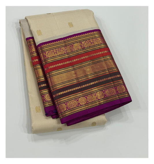 Folded ivory handwoven Kanchipuram silk saree with magenta and gold-toned contrast border