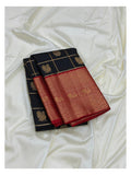 Folded navy blue Kanchipuram silk saree with gold-toned checks and broad red woven border