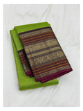 Folded parrot green Kanchipuram silk saree with plum and gold-toned border