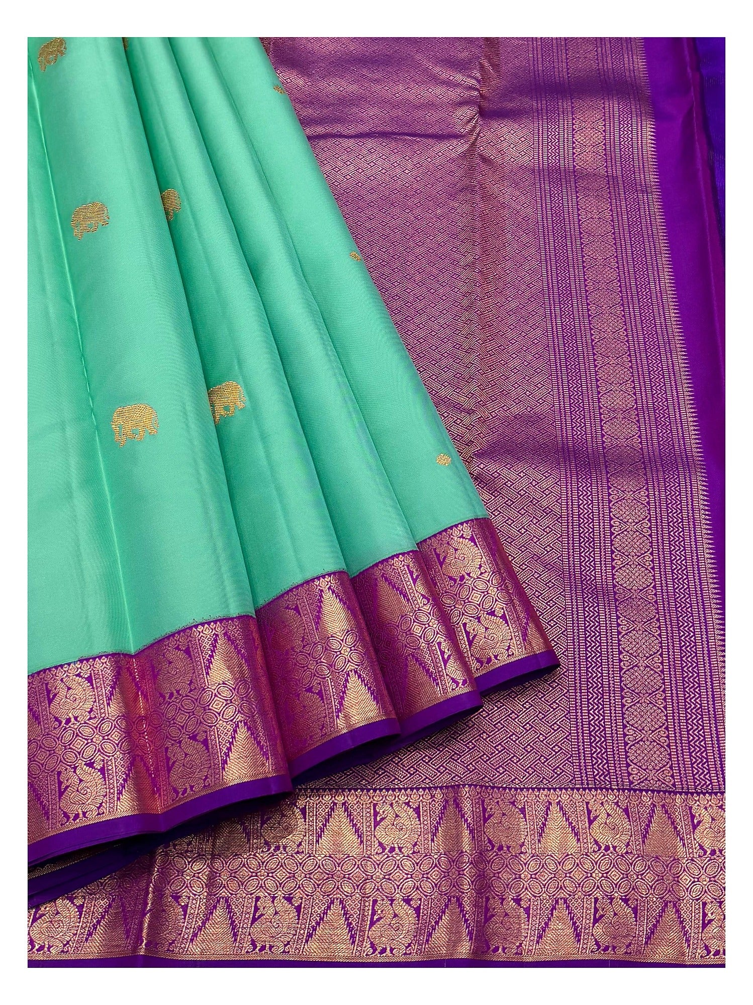 Detailed view of the aqua green saree with elephant motifs, purple woven border, and richly patterned purple pallu