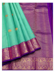 Detailed view of the aqua green saree with elephant motifs, purple woven border, and richly patterned purple pallu