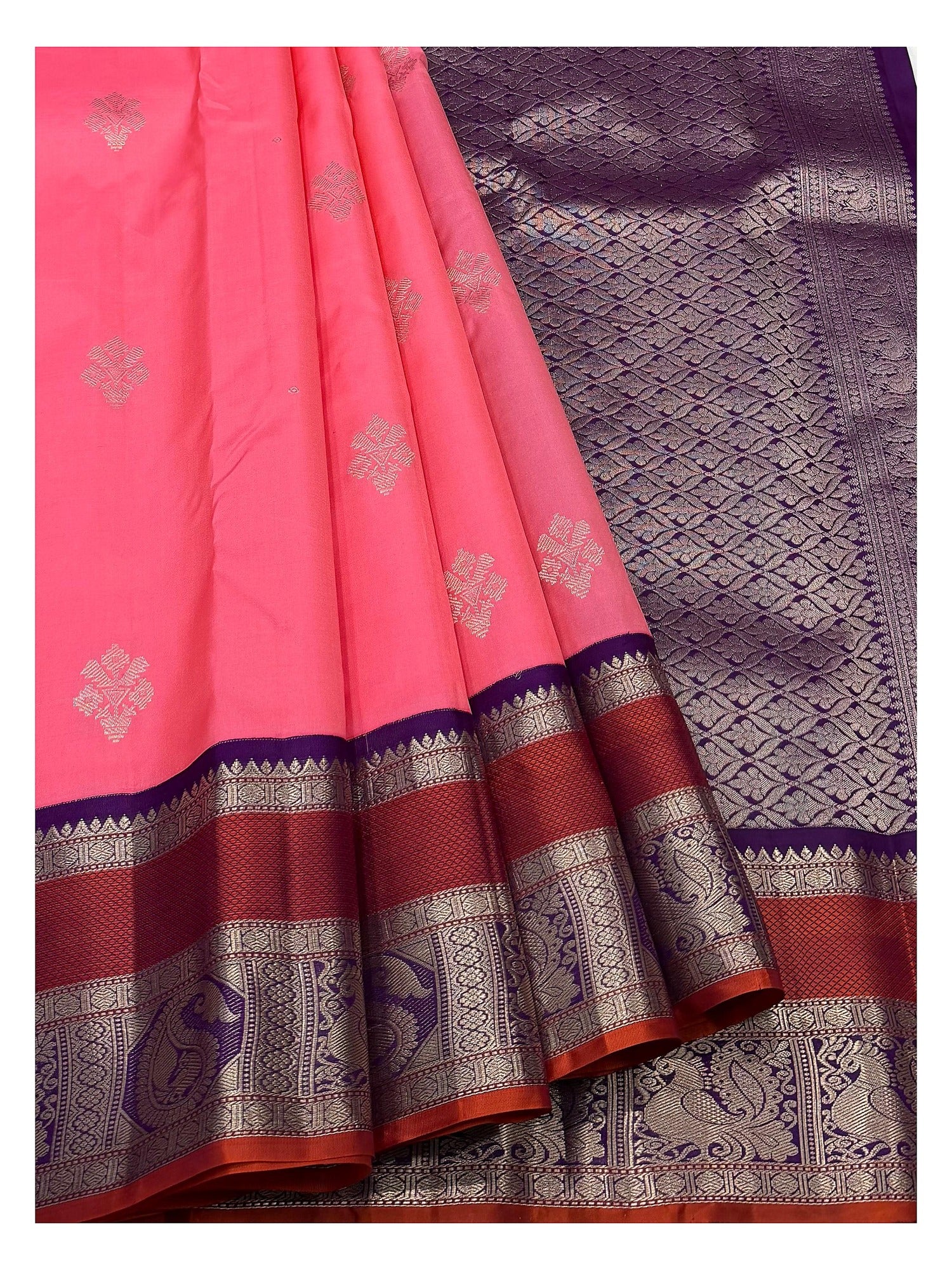 Bright pink pure silk saree drape with silver-toned buttas and purple peacock pallu
