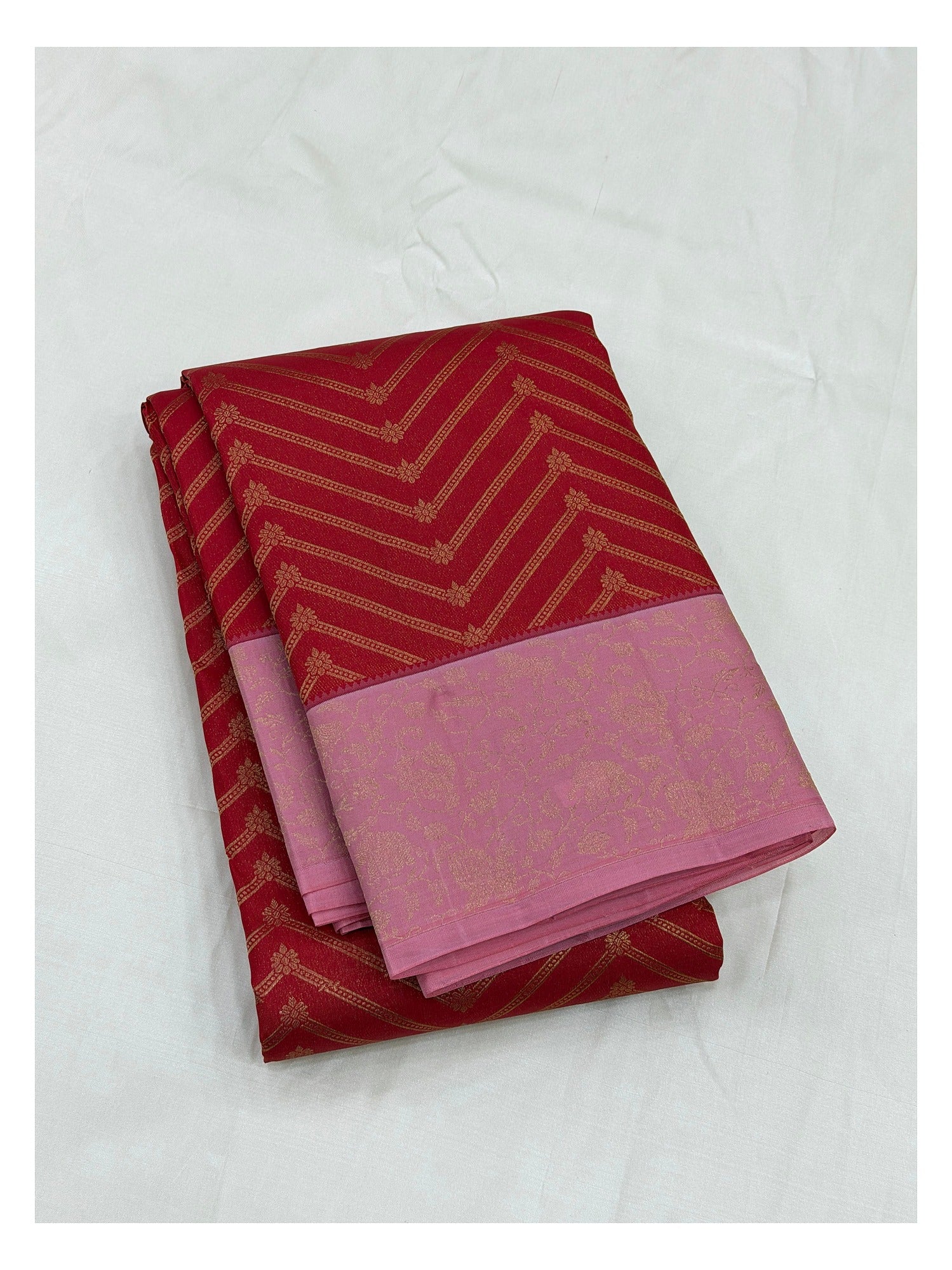 Folded pure silk saree in red with gold-toned chevron motifs and pink floral border