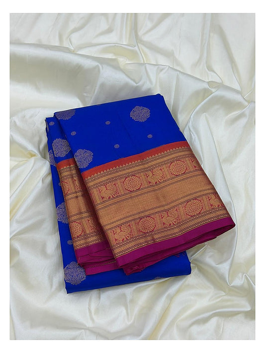 Royal blue pure silk saree folded with broad gold-toned woven border and magenta contrast