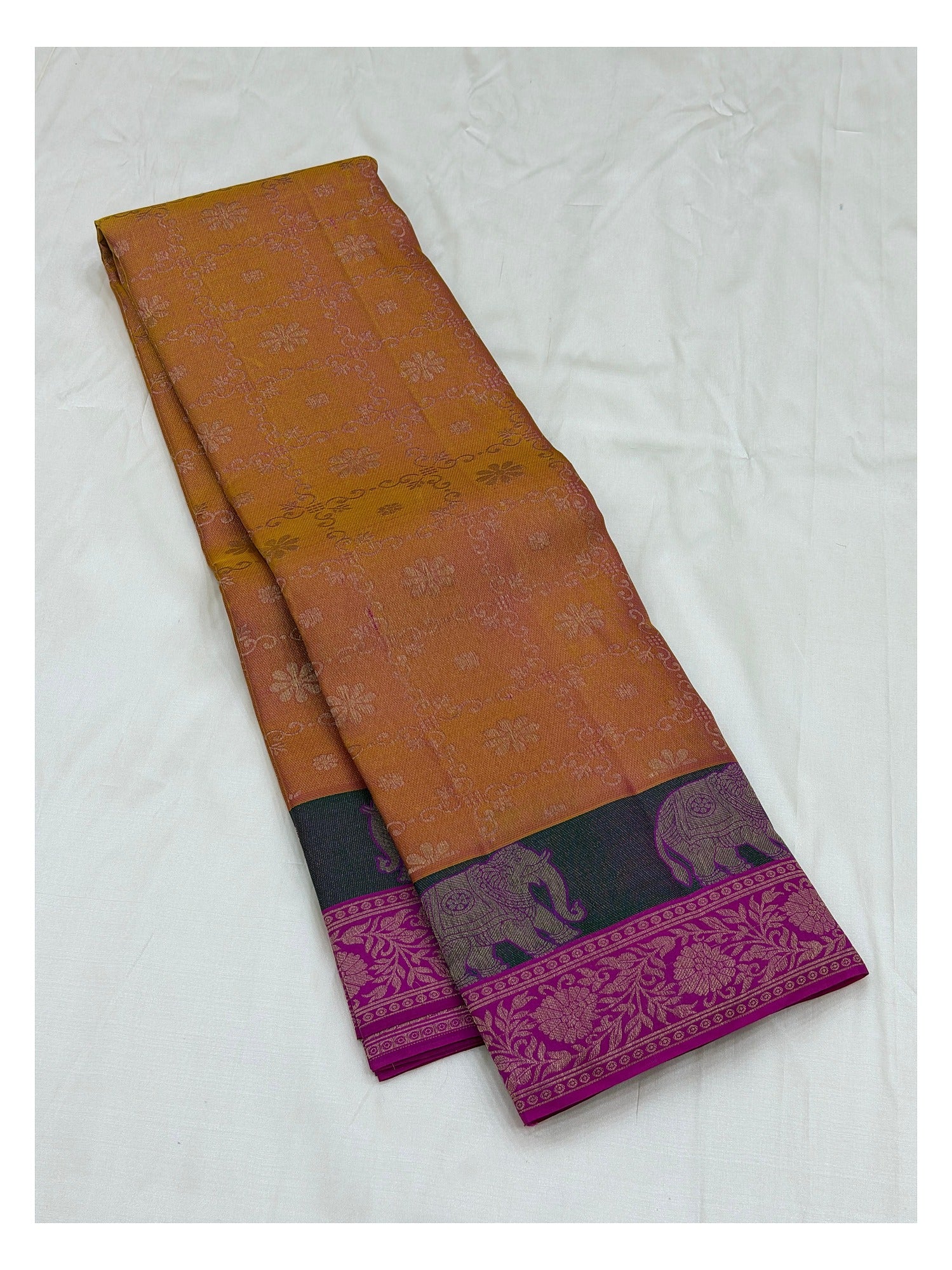 Folded mustard pure silk saree showing elephant motif contrast border and magenta border