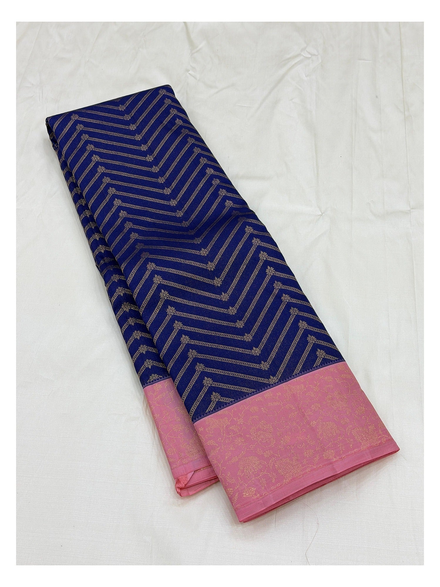 Royal blue saree with pink floral zari border laid folded