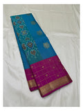 Full view of sky blue silk saree with gold motifs, teal ikat-style pallu and magenta zari border