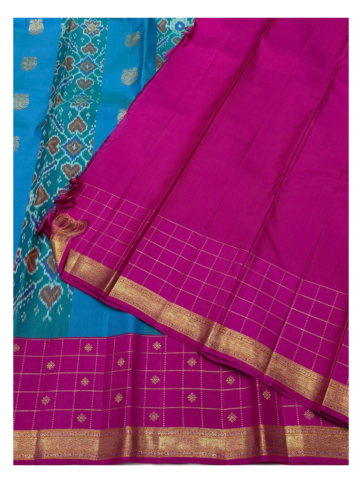 Contrast magenta blouse piece with zari border beside the saree border