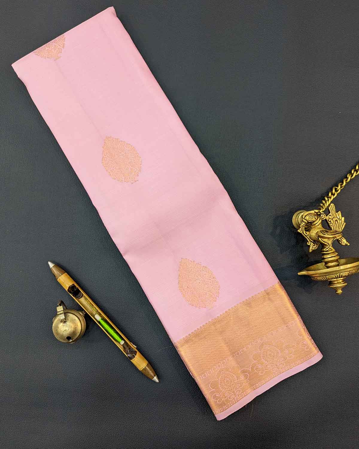 Beautiful light pink floral buttas adorn these traditional Kancheepuram silk sarees with self-designed borders